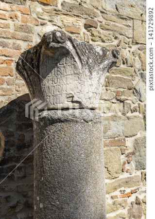 Ancient stone column capital showing historical inscription in Cortona, Italy 141729892
