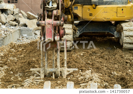 Debris and excavators on the site of a house where demolition work is underway. Debris and excavators on the site of a house where demolition work is underway. 141730057