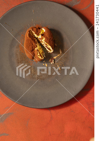 Chocolate orange dessert with cocoa powder and creme filling Chocolate orange dessert with cocoa powder and creme filling 141730441