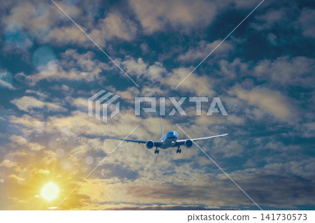 Passenger Plane Approaching Through Dramatic Sunset Sky Passenger Plane Approaching Through Dramatic Sunset Sky 141730573