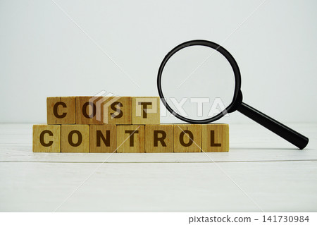 COST CONTROL alphabet letters with magnifying glass on wooden background 141730984