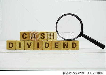 CASH DIVIDEND alphabet letters with magnifying glass on wooden background CASH DIVIDEND alphabet letters with magnifying glass on wooden background 141731002