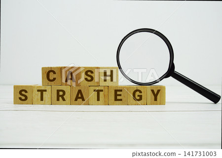 CASH STRATEGY alphabet letters with magnifying glass on wooden background CASH STRATEGY alphabet letters with magnifying glass on wooden background 141731003