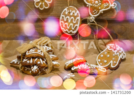Royal icing cookies. Christmas gingerbread cookies on wooden table top view. Flat lay of Christmas gingerbread cookies on wooden background. Sprinkle accents introduce vibrant contrast. Royal icing cookies. Christmas gingerbread cookies on wooden table top view. Flat lay of Christmas gingerbread cookies on wooden background. Sprinkle accents introduce vibrant contrast. 141731200