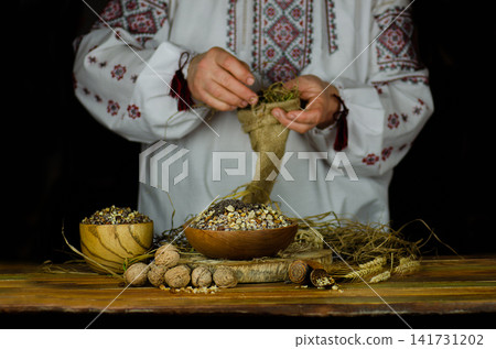 Hands interact with traditional kutia and symbolic objects in scenes depicting Christmas ceremony. Hands interact with traditional kutia and symbolic objects in scenes depicting Christmas ceremony. 141731202