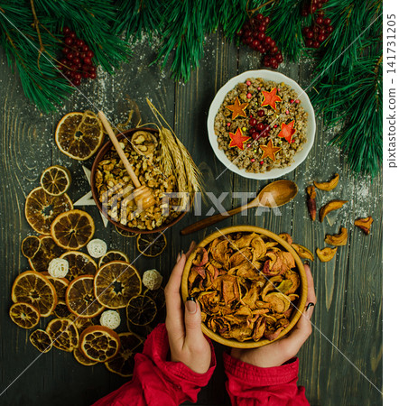 Top view composition on dark wooden surface is decorated with dried orange slices, white star ornaments, pine branches, red berries, and christmas balls. Top view composition on dark wooden surface is decorated with dried orange slices, white star ornaments, pine branches, red berries, and christmas balls. 141731205
