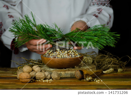 Hands interact with traditional kutia and symbolic objects in scenes depicting Christmas ceremony. Hands interact with traditional kutia and symbolic objects in scenes depicting Christmas ceremony. 141731206
