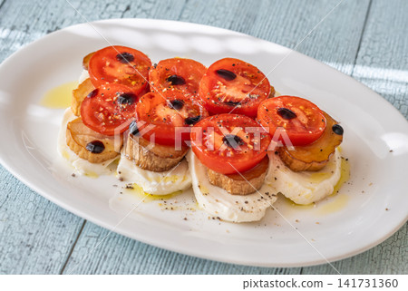Elegant Caprese salad with mozzarella tomatoes king oyster mushrooms balsamic olive oil appetizer platter Elegant Caprese salad with mozzarella tomatoes king oyster mushrooms balsamic olive oil appetizer platter 141731360