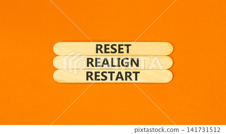Reset realign restart words symbol. Concept words Reset realign restart on beautiful wooden sticks. Beautiful orange background. Business motivational and reset realign restart concept. Copy space. 141731512