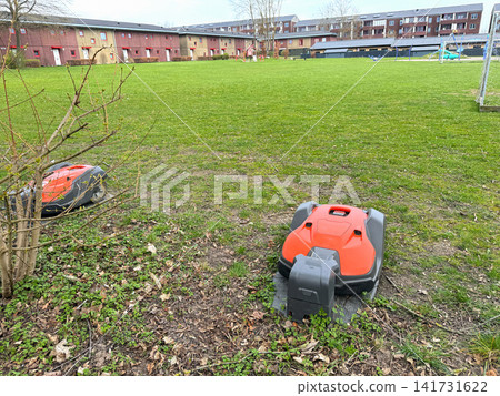 Robotic lawn mower on grass in garden. Robotic lawn mower on grass in garden. 141731622
