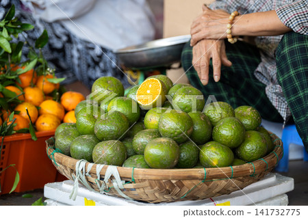 Ripe fresh green tangerines exotic fruits in basket on display selling at street food market. Ripe fresh green tangerines exotic fruits in basket on display selling at street food market. 141732775