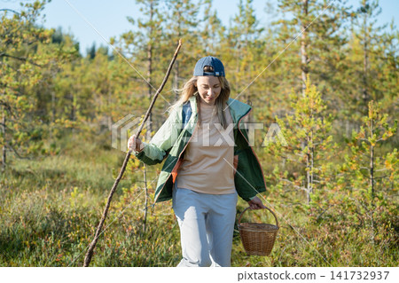 Confident woman backpacker strolling through forest, physical activity outdoors and healthy living Confident woman backpacker strolling through forest, physical activity outdoors and healthy living 141732937