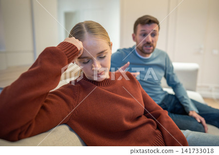 Disappointed apathetic wife listening to male partner dishonest confessions during family quarrel Disappointed apathetic wife listening to male partner dishonest confessions during family quarrel 141733018