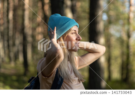 Positivity, slow living and recreation, happy woman hiker enjoys forest walk observing summer nature Positivity, slow living and recreation, happy woman hiker enjoys forest walk observing summer nature 141733043