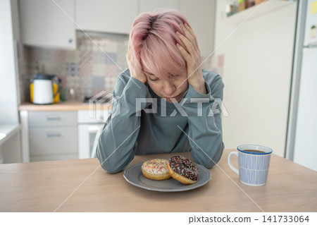 Depressed stressed mature woman suffering from psychological issues and overeating sweet food, Depressed stressed mature woman suffering from psychological issues and overeating sweet food, 141733064