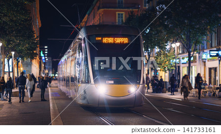 Nice, France - November 2, 2018 - Tram at night on Massena square with pedestrians 141733161