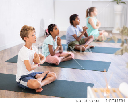 Training yoga kids on yoga mat in gym. Training yoga kids on yoga mat in gym. 141733764