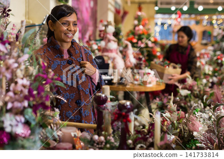 Woman choosing New Year's tree in christmas street fair Woman choosing New Year's tree in christmas street fair 141733814
