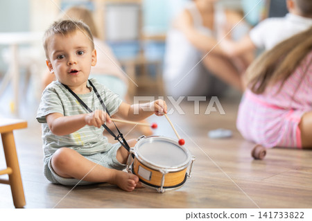 6 year boy plays with toys in front of other children in kindergarten 6 year boy plays with toys in front of other children in kindergarten 141733822