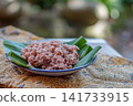 Traditional Indonesian brown rice served on banana leaf plate with natural lighting. Healthy Asian food, whole grain rice, authentic Southeast Asian cuisine. 141733915
