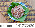 Close up of brown rice texture served on banana leaf. Healthy whole grain Asian food ingredient with natural daylight. 141733920