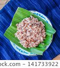Close up of brown rice texture served on banana leaf. Healthy whole grain Asian food ingredient with natural daylight. 141733922