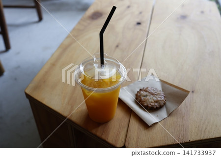Cafe snacks. Orange juice and cookies. Wooden table. Cafe snacks. Orange juice and cookies. Wooden table. 141733937