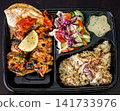 Top view of a grilled chicken meal served with rice, fresh salad, pita bread and sauce in a compartmentalized takeaway box. Healthy and balanced food concept. 141733976