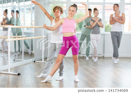 Ballet studio - teenagers girls and boys learn ballet movements in pairs Ballet studio - teenagers girls and boys learn ballet movements in pairs 141734089