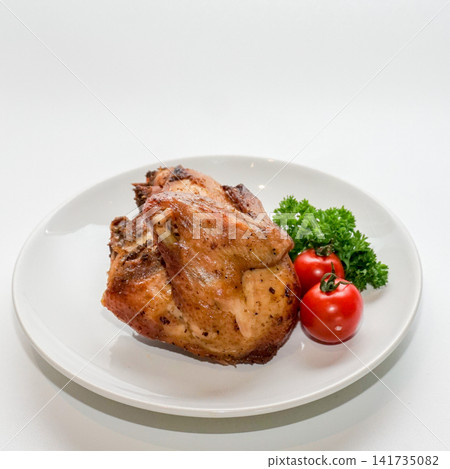 Roasted chicken breast quarter served on white plate with parsley and cherry tomato. Roasted chicken breast quarter served on white plate with parsley and cherry tomato. 141735082