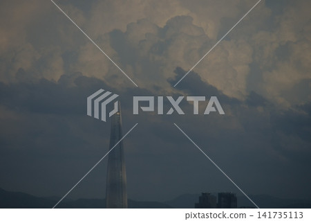 Urban apartment complex under a blue sky and fluffy white clouds Urban apartment complex under a blue sky and fluffy white clouds 141735113