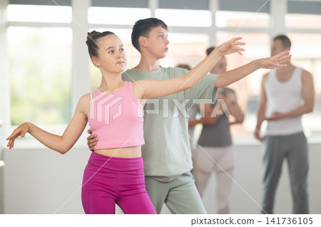 Boy and girl in pair train to perform ballet dance during rehearsal in studio Boy and girl in pair train to perform ballet dance during rehearsal in studio 141736105
