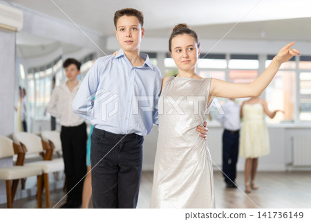 Adolescent ballroom dancers practicing elegant dance moves in pairs Adolescent ballroom dancers practicing elegant dance moves in pairs 141736149
