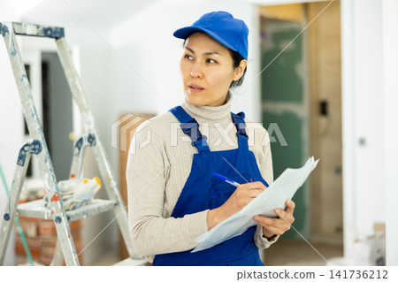 Woman builder checking project documentation Woman builder checking project documentation 141736212