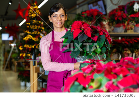 Woman owner flower shop with christmas flower Woman owner flower shop with christmas flower 141736303