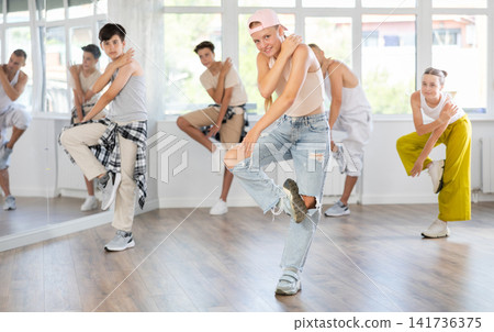 Teenagers in casual clothes are training together to dance hip-hop and breakdancing in dance center Teenagers in casual clothes are training together to dance hip-hop and breakdancing in dance center 141736375