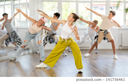 Teen girl with group of teenage friends, learn to dance hip hop Teen girl with group of teenage friends, learn to dance hip hop 141736461