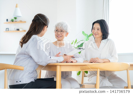 A worker and a senior woman discussing renovation plans. A worker and a senior woman discussing renovation plans. 141736579