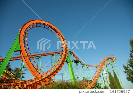 Colorful roller coaster features thrilling loops and turns at amusement park Colorful roller coaster features thrilling loops and turns at amusement park 141736957