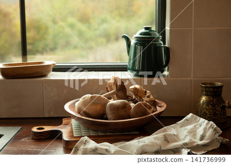 Fresh variety of mushrooms displayed in wooden bowl on kitchen counter Fresh variety of mushrooms displayed in wooden bowl on kitchen counter 141736999