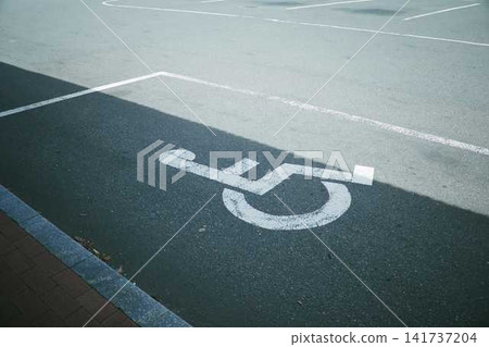 停車場瀝青路面上標示輪椅無障礙停車位。 停車場瀝青路面上標示輪椅無障礙停車位。 141737204