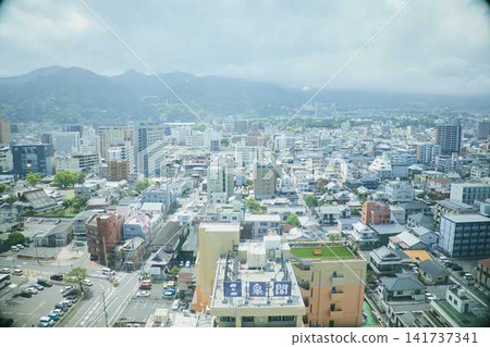 The cityscape and hot spring resort area spread out against the backdrop of the Beppu mountain range. The cityscape and hot spring resort area spread out against the backdrop of the Beppu mountain range. 141737341