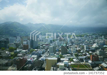 The cityscape and hot spring resort area spread out against the backdrop of the Beppu mountain range. The cityscape and hot spring resort area spread out against the backdrop of the Beppu mountain range. 141737352