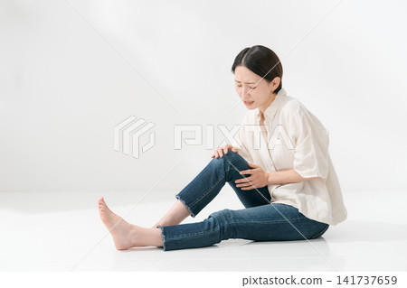 A woman who appears to be in pain in her leg. A woman who appears to be in pain in her leg. 141737659