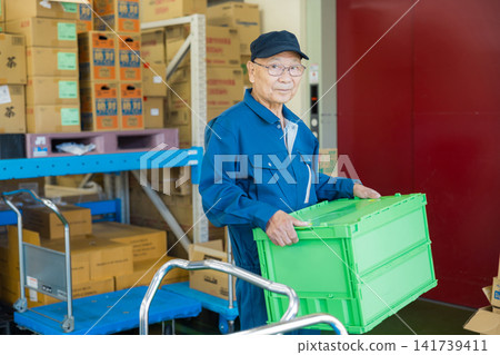 A man working in a warehouse A man working in a warehouse 141739411