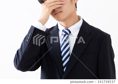 A young businessman in a suit looks dejected. A young businessman in a suit looks dejected. 141739537
