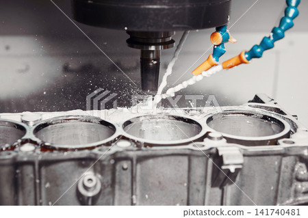 CNC milling machine grinds holes in car engine with coolant. Process of setting up engine cylinder blocks on a numerically controlled machine. CNC milling machine grinds holes in car engine with coolant. Process of setting up engine cylinder blocks on a numerically controlled machine. 141740481