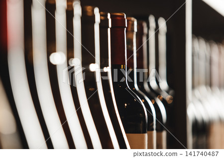 Close-Up of Elite Wine Bottles Lined Up on Shelf With Soft Lighting Close-Up of Elite Wine Bottles Lined Up on Shelf With Soft Lighting 141740487