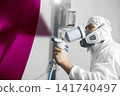 Car painter spraying paint with spray gun on part of car in paint chamber, complex painting, heavy color selection. Restoration of automobile after the accident. 141740497