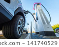 Electric car charging at a outdoor public charging station. Electric car charging at a outdoor public charging station. 141740529